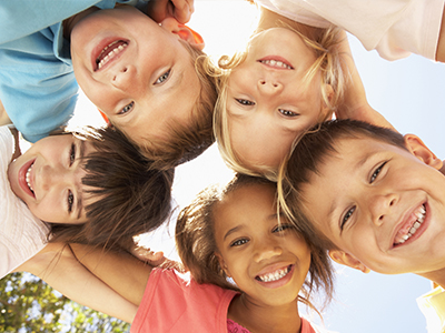 A group of children, both boys and girls, are smiling and posing together for a photo.